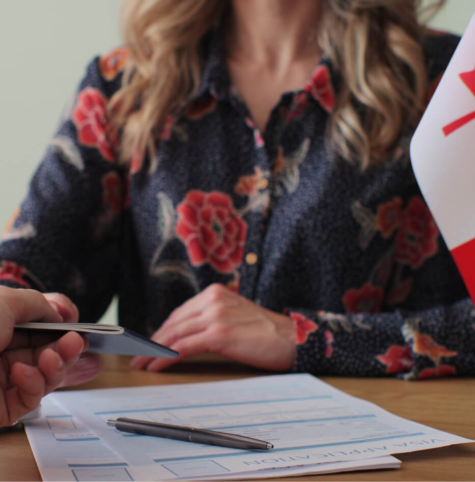Visa application handover with Canadian flag visible.